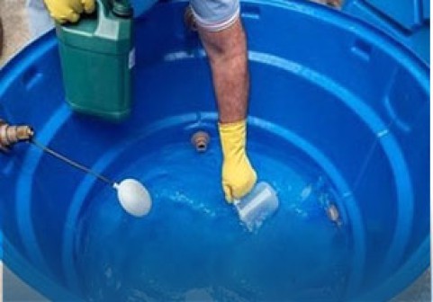 [Imagem de uma caixa d'água sendo limpa por um profissional]